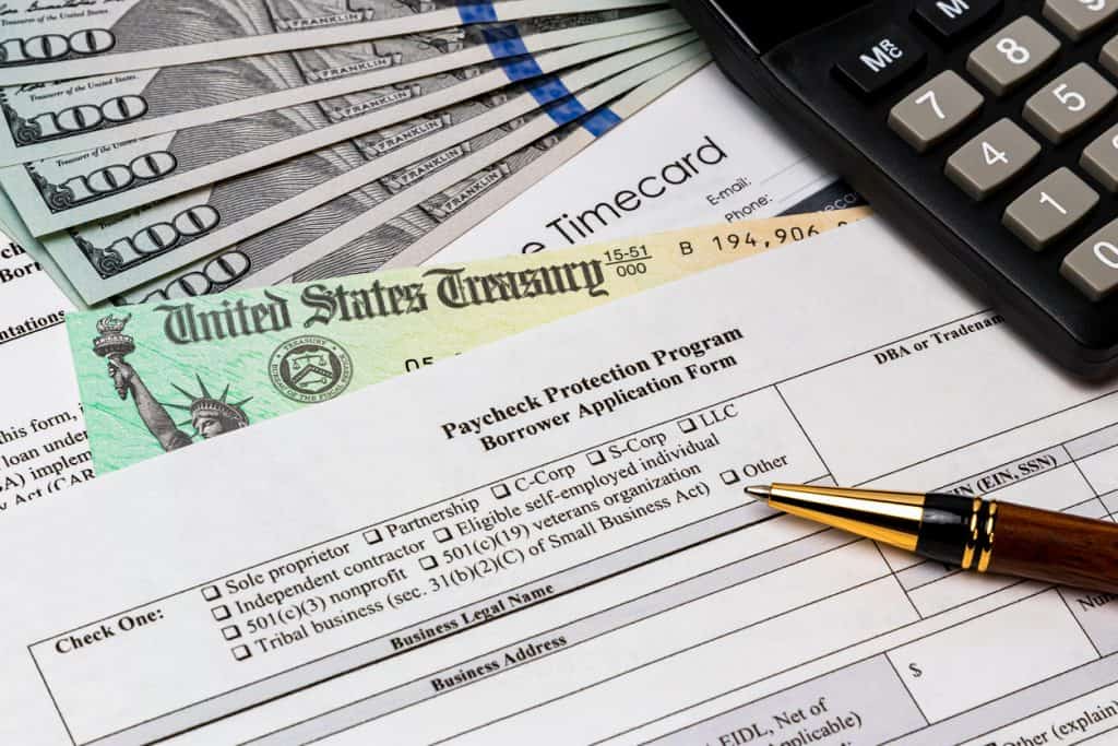 A paycheck protection program loan application on top of an IRS check